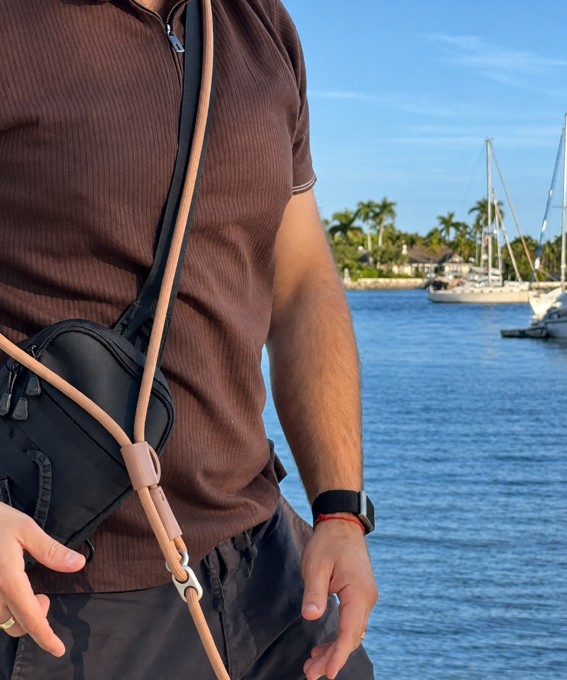 Close-up of the DoggiiStyle hands-free leash worn across the body beside a marina